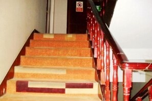 Een trap met rode leuningen en beige treden.