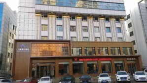 A multi-story building with a modern facade, a digital display board, and a series of doors likely leading to commercial spaces. - Tianxing Hotel (Lingshi)