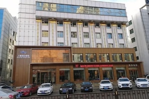 A multi-story building with a modern facade, a large digital display, and several ground-level entrances.