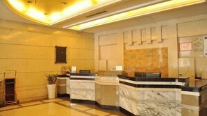 A hotel reception area with marble counters, a reception desk, a wall-mounted information board, and a 'WiFi' sign. - Tianxing Hotel (Lingshi)