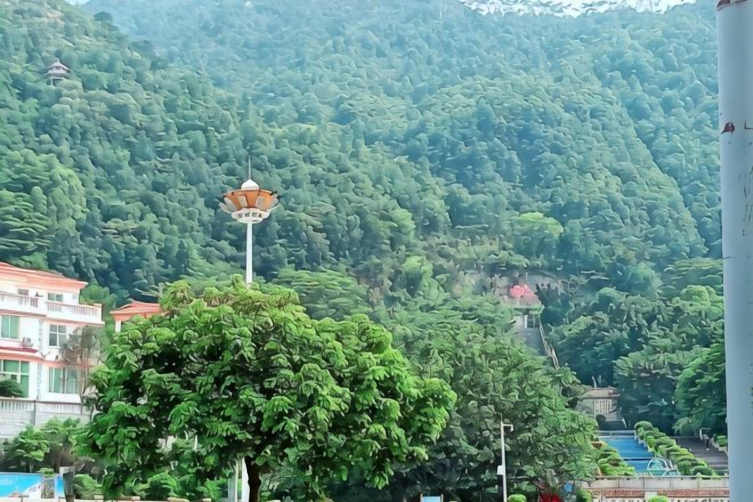 Un paysage montagneux avec un lampadaire et des bâtiments au premier plan.