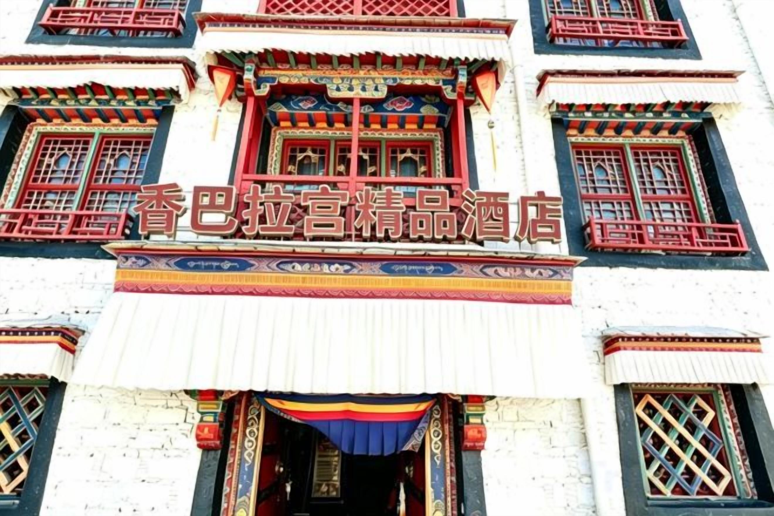 Un edificio con elementos arquitectónicos tradicionales, como ventanas ornamentadas y un letrero con caracteres chinos.