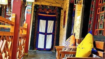 A traditional building with a wooden door, benches, and a stone wall.