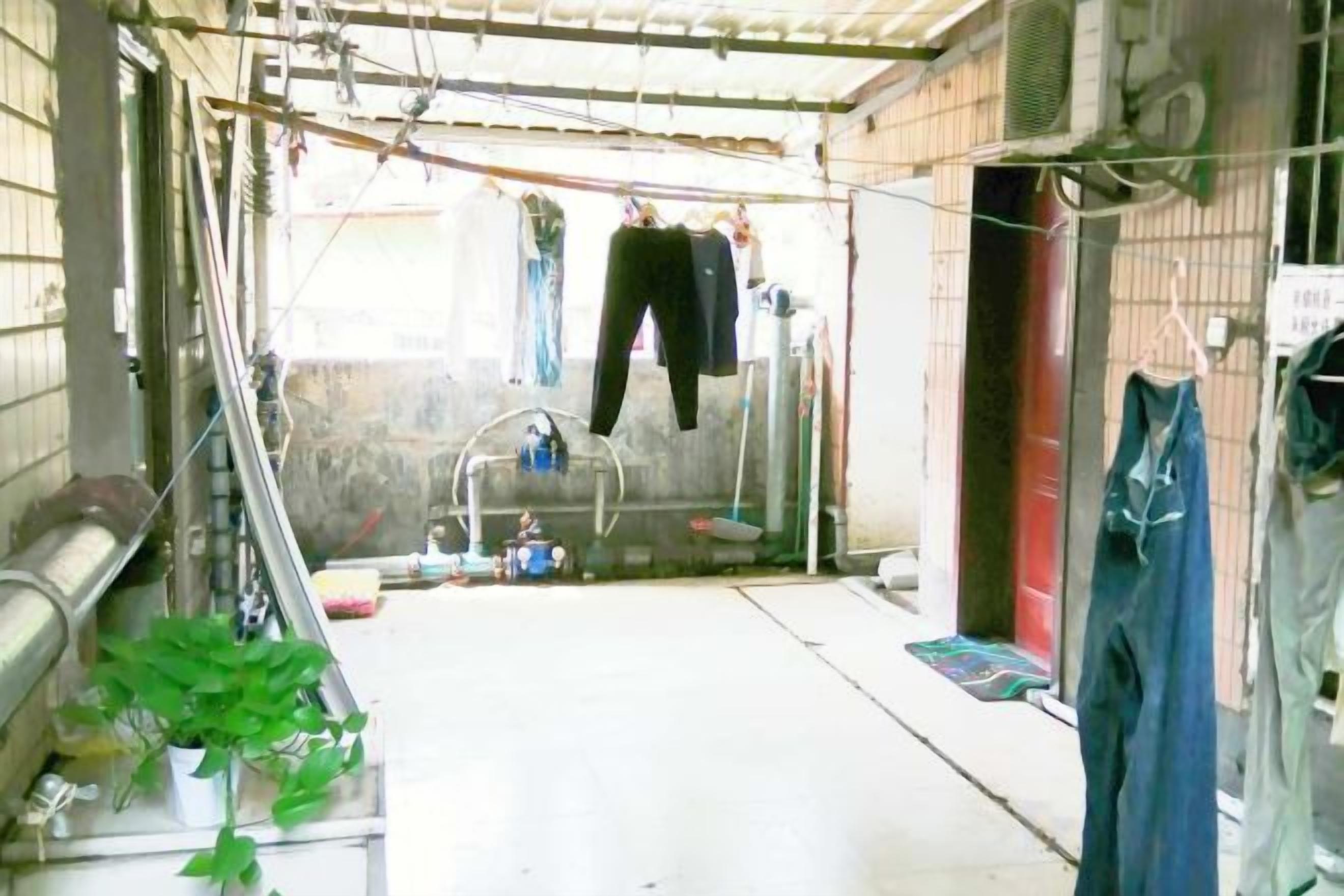 Un área de lavandería con ropa colgada, una lavadora y un tendedero.