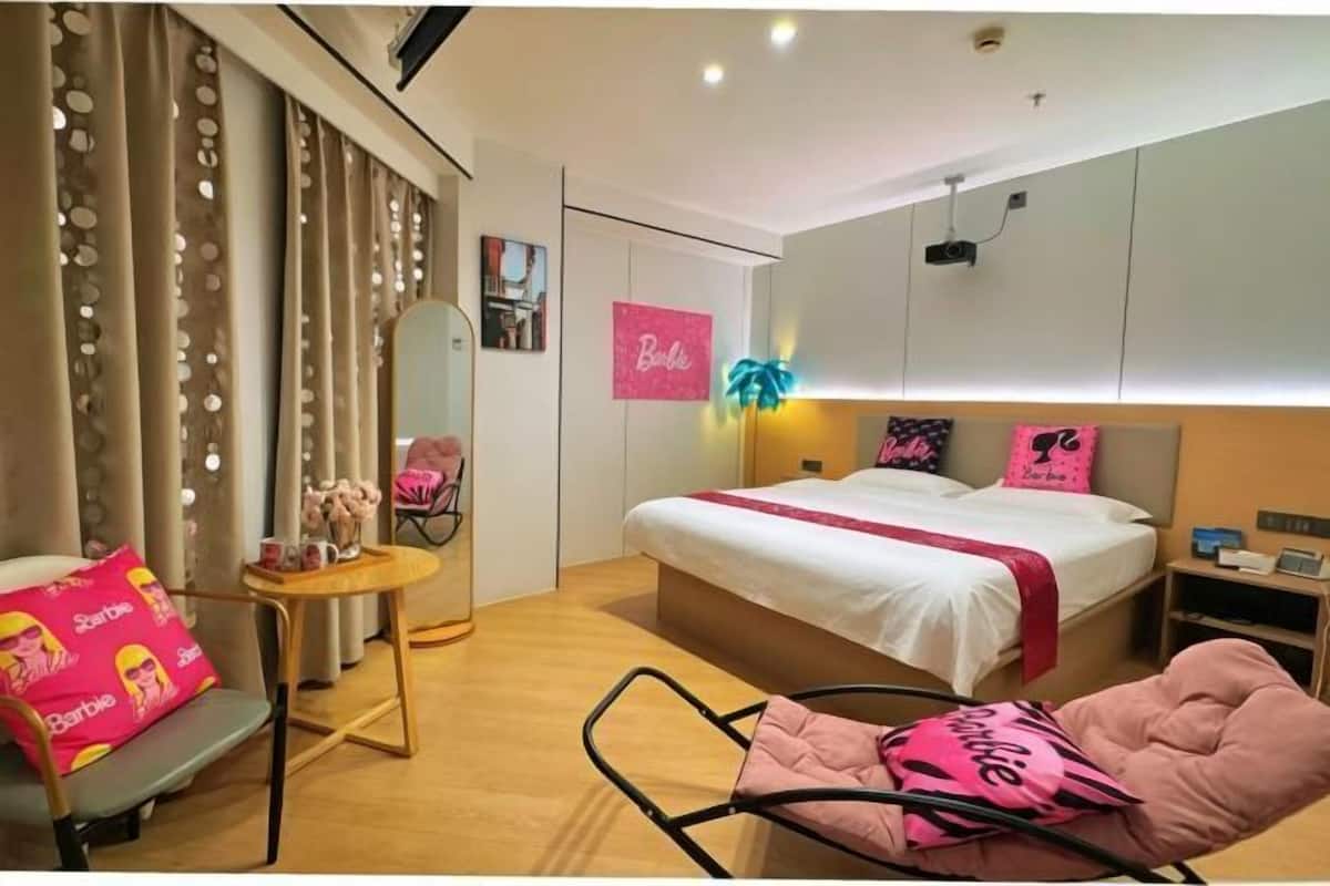 A bedroom with a bed, a chair, a small table, and a mirror.