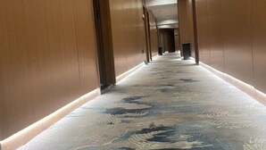 A long hallway with wooden paneling and a patterned carpet. - Sihe Haichuan Hostel (Nanping)