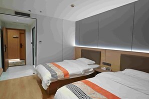 A hotel room with two beds, a wooden door, a mirror, and a large wall unit. - Sihe Haichuan Hostel (Nanping)
