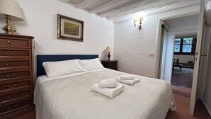 Une chambre à coucher avec un grand lit, une commode, un tableau au mur et une lampe.