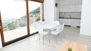 Une cuisine moderne avec des armoires blanches et une grande fenêtre donnant sur un paysage magnifique.