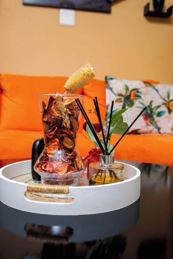 A glass vase with dried flowers and a candle on a table. - WoodMead Guest House & Events (Manzini)