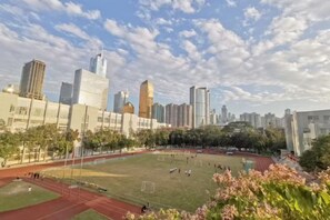 A cityscape with modern buildings, a sports field, and a clear sky. - Wings Hotel(East Railway Station Sports Institute Branch) (Guangzhou)
