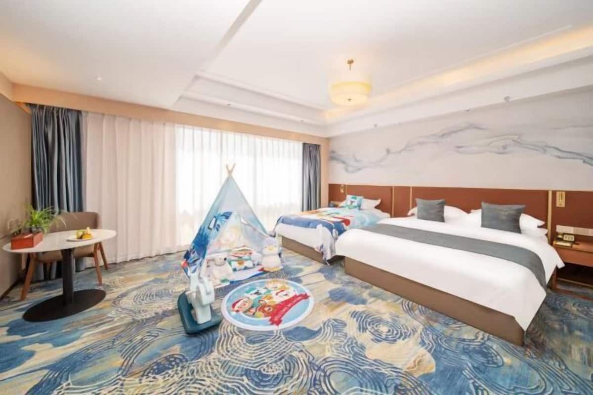 Ein Hotelzimmer mit einem Bett, einem kleinen Tisch mit Pflanze, einem Zelt und einem Wandgemälde.