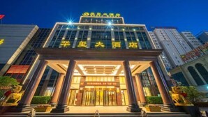 A hotel entrance with a modern facade, illuminated signage, and a set of double doors. - Zhucheng Huaxi Grand Hotel (Zhucheng)