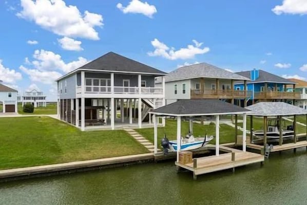 A waterfront property with a large house featuring a covered porch and a boat dock. - Boaters' paradise, direct access to the Intracoastal, East Bay and Gulf. (Bolivar Peninsula)