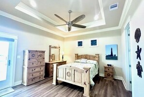 A bedroom with a bed, dresser, nightstands, and a ceiling fan. - Boaters' paradise, direct access to the Intracoastal, East Bay and Gulf. (Bolivar Peninsula)