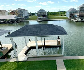 A waterfront property with a covered dock, a small pool, and a grassy area. - Boaters' paradise, direct access to the Intracoastal, East Bay and Gulf. (Bolivar Peninsula)