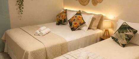 A hotel room with two beds, a wall-mounted air conditioner, and a decorative wall piece.