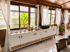 A breakfast buffet setup with a coffee maker, jars, and a food display.