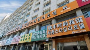 A multi-story building with various business signs. - Yanji Ruifeng Hotel (Yanji)