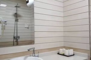 A bathroom with a sink, mirror, and toiletries.