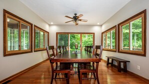 A spacious dining room with a large wooden table, multiple chairs, and a ceiling fan. - Private Hilltop Retreat | Hot Tub & 15 Min to Nashville3BR, 3.5 BA (Nashville)