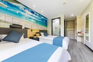 A hotel room with two beds, a mural of a beach scene, a small desk, and a bathroom visible through an open door. - Shaoxing Shun'an Collection Hotel (Lu Xun's Hometown Yintai Branch) (Shaoxing)