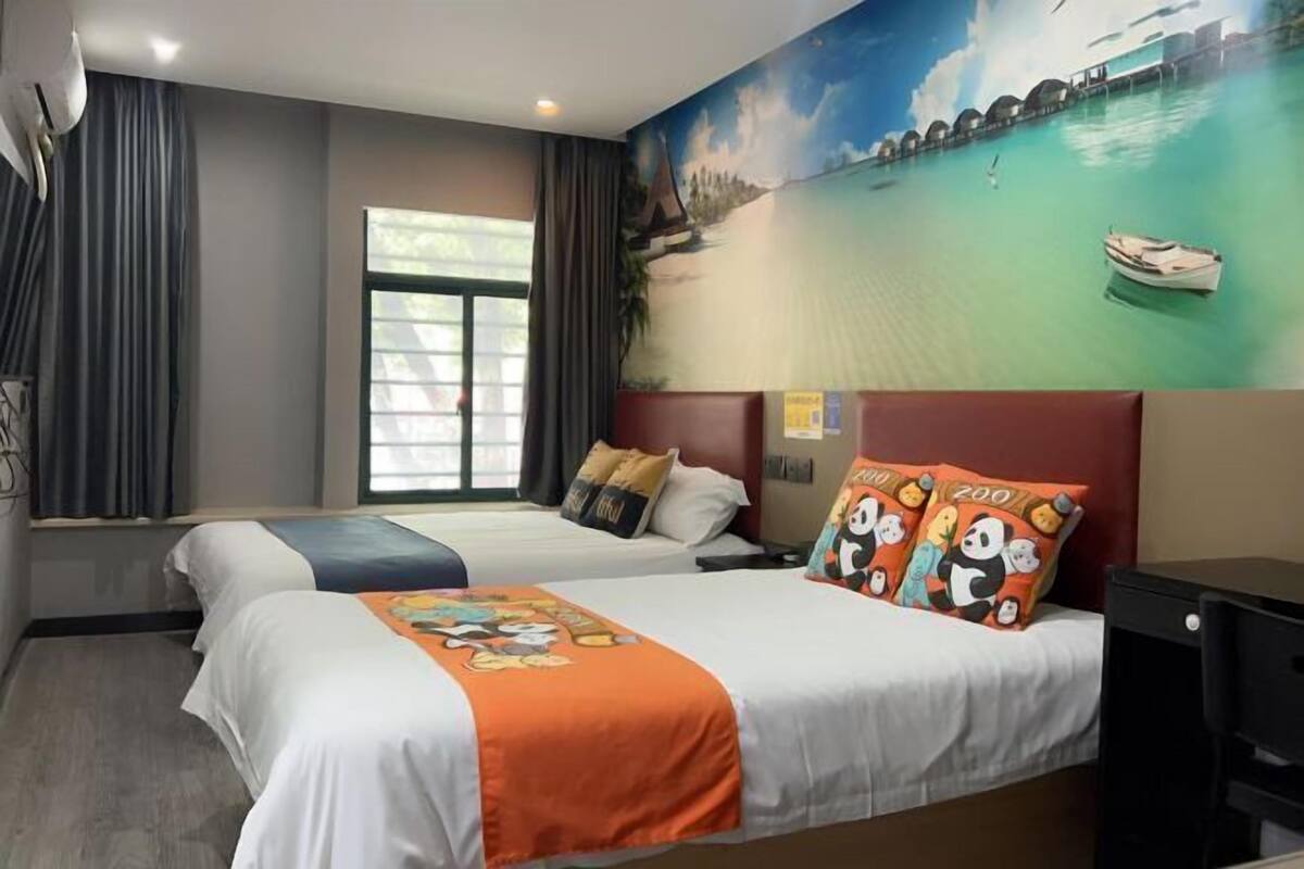 Una habitación de hotel con dos camas, un mural de playa tropical y una ventana con cortinas.