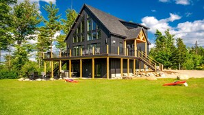 A modern two-story house with a large deck, outdoor seating, and a canoe. - Epic mountain views, Hot tub and Game room (Bethel)