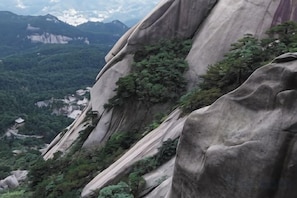 Un paysage montagneux accidenté, caractérisé par de hautes formations rocheuses et une végétation luxuriante.
