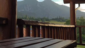 En träbalkong med utsikt över ett bergskedja.