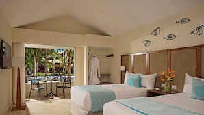 A hotel room with two beds, a balcony with a table and chairs, and a view of the outdoors. - Riviera del Mar (Puerto Plata)