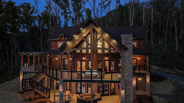 A large log cabin with a spacious deck, multiple levels, and a stone exterior. - Smoky Mtn Luxury: Views, Theater, Outdoor Kitchen (Sevierville)
