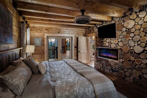 Un dormitorio acogedor con una cama grande, una chimenea y una pared de piedra.