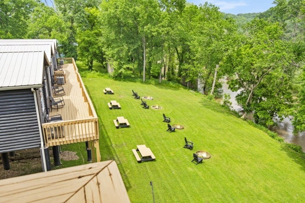 A deck with outdoor seating and a view of a river.