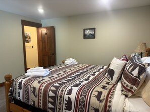 A bedroom with a bed, a wooden door, a framed picture on the wall, and a lamp. - 1 BR Lakeview, 5 Mins to Glacier (West Glacier)