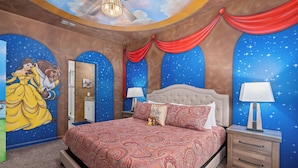 A bedroom with a bed, nightstands, and a mural of a princess and a beast.