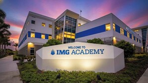 La façade de l’IMG Academy, avec une enseigne sur laquelle on peut lire « BIENVENUE À L’IMG ACADEMY », et un bâtiment moderne doté de grandes fenêtres en verre et d’une palette de couleurs bleue et blanche.