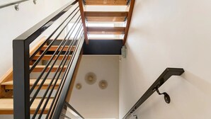 A modern staircase with wooden steps and metal railings, leading to an upper floor. - Walk to Space Needle from a Cap Hill Loft w/VIEWS (Seattle)