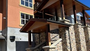 A multi-story building with a stone facade, a wooden balcony, and a staircase leading to the upper level.