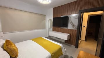 Escritorio, cortinas blackout y tabla de planchar con plancha