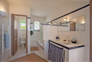 A modern bathroom with a bathtub, a sink, and a toilet. - Casa Marinu Muntese (Brando)