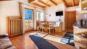 Un interior de madera con comedor, cocina y vistas a las montañas.
