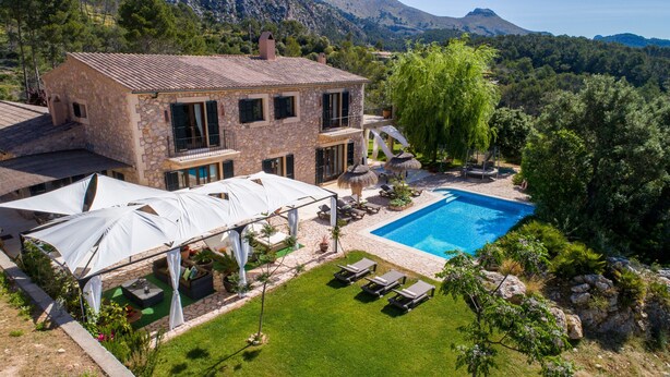A stone house with a swimming pool, outdoor seating, and a view of the surrounding landscape. - Luxurious villa with sea views and surrounded by nature at 10 min from Andratx (Andratx)