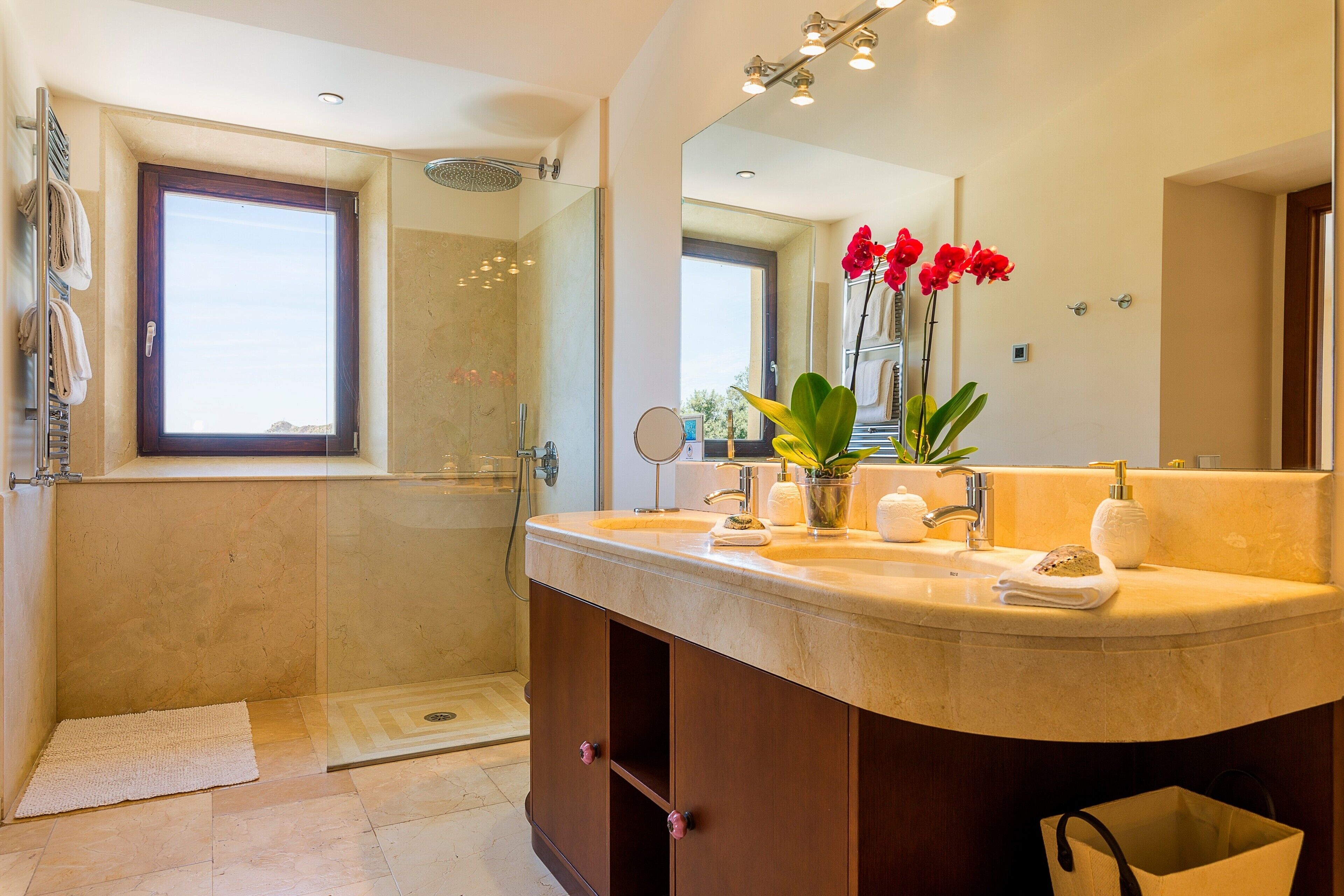 A modern bathroom with a large mirror, a shower, and a vanity with a sink and towel rack.