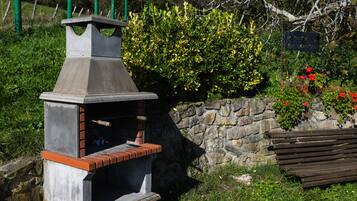 A stone wall with a brick oven and a wooden bench.