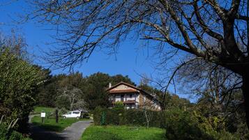 Una casa con un sendero que la lleva, rodeada de árboles y follaje.