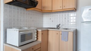 Une cuisine avec des meubles de rangement en bois, un four à micro-ondes, une cuisinière et un réfrigérateur.