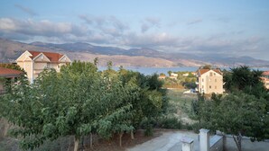 Un quartier résidentiel avec des maisons, un ciel dégagé et des montagnes en arrière-plan.