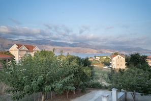 A residential area with houses, a clear sky, and mountains in the background.