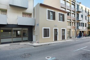 Un immeuble à plusieurs étages, doté d’un espace commercial au rez-de-chaussée, d’une entrée bien visible et d’une échelle de secours.